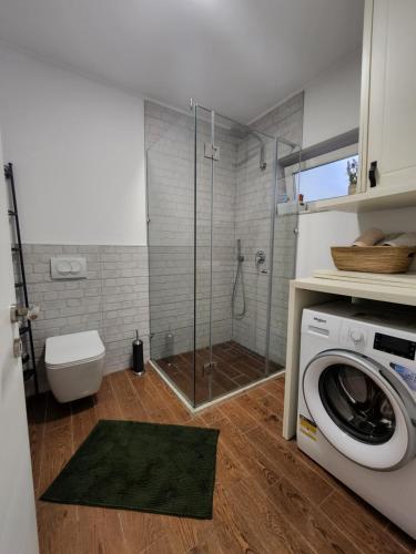 a bathroom with a shower and a washing machine at TRAVELER'S PLACE at Tirana City Centre in Tirana
