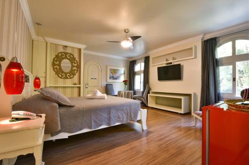 a bedroom with a bed and a living room at Doce Canela - Pousada de Charme in Canela