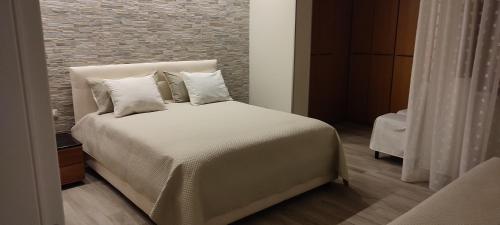 Schlafzimmer mit einem Bett mit weißer Bettwäsche und Kissen in der Unterkunft Dimora Il Tulipano in Vieste