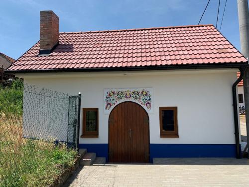 a small white house with a brown door at Vinný sklep S&T Výmola in Mikulčice