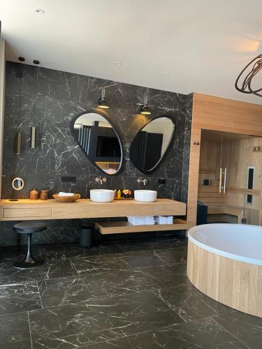 a bathroom with two sinks and a bath tub at Brabant Suites in Nistelrode