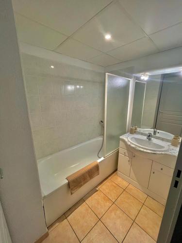 une salle de bain avec une douche, un lavabo et une baignoire dans l'établissement appartement en résidence très bien situé, à Uzès