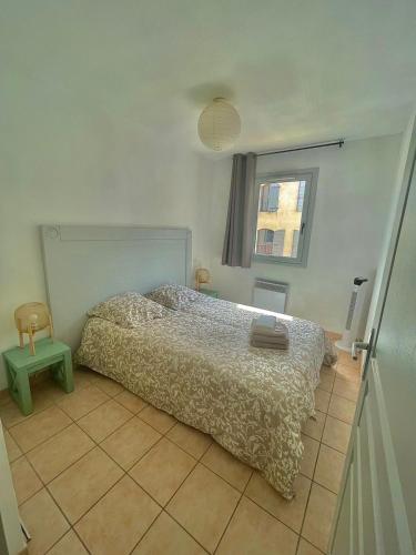 une chambre avec un lit et une fenêtre dans l'établissement appartement en résidence très bien situé, à Uzès