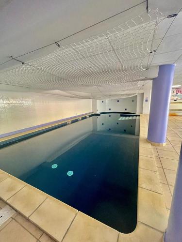 une grande piscine avec de l'eau bleue dans un immeuble dans l'établissement appartement en résidence très bien situé, à Uzès
