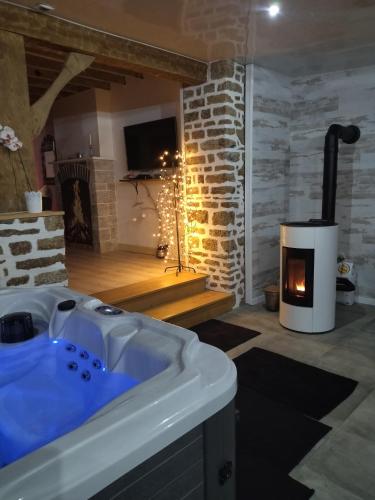 a bath tub in a room with a fireplace at la caliente in Saint-Mars-sur-la-Futaie