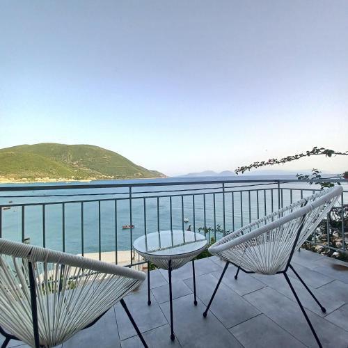 een balkon met een tafel en stoelen en de oceaan bij Ponti Bay Apartments in Vasiliki
