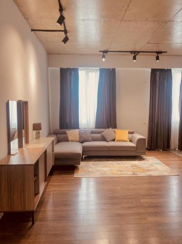a living room with a couch and a television at APARTMENT SIXTEEN in Tbilisi City