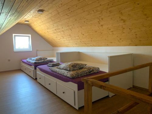 2 camas en una habitación con techo de madera en Vinný sklep S&T Výmola, en Mikulčice
