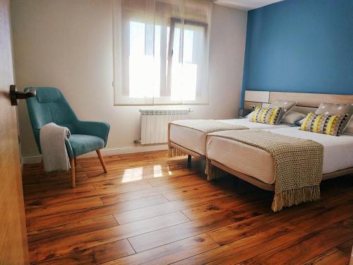 ein Schlafzimmer mit einem Bett, einem Stuhl und einem Fenster in der Unterkunft Apartamento Casa A Braña in O Grove