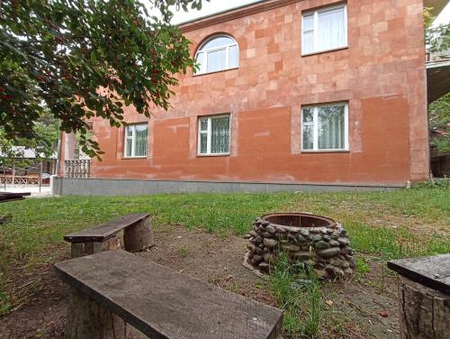 a brick building with two benches and a barrel at Green Garden in Ijevan