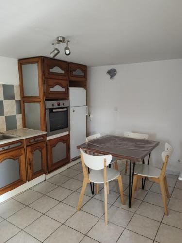 une cuisine avec une table, des chaises et un réfrigérateur dans l'établissement Appartement T2 Roquebrune sur Argens, à Roquebrune-sur Argens