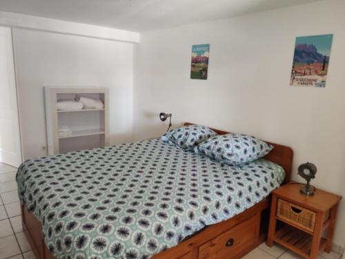 um quarto com uma cama e uma mesa com uma mesa de cabeceira em Appartement T2 Roquebrune sur Argens em Roquebrune-sur-Argens
