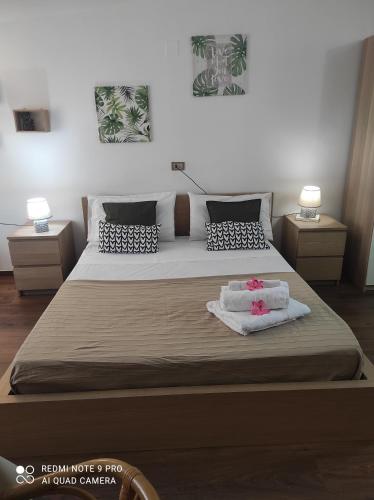 a bedroom with a large bed with two night stands at Ohana B&B in Marina di Camerota