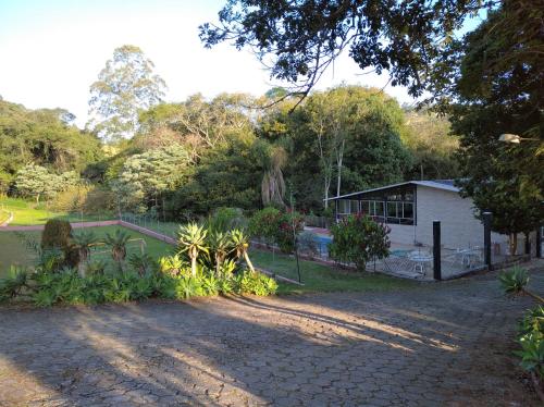 a yard with a house and a fence at Pousada Juriti - Eco Hotel in São Roque