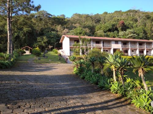 a building with palm trees in front of it at Pousada Juriti - Eco Hotel in São Roque