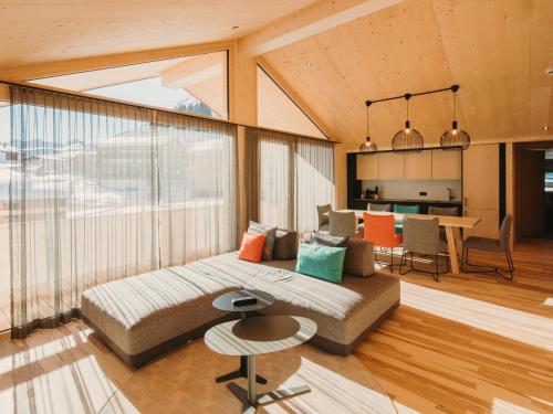 uma sala de estar com um sofá e uma mesa em Alpin - Studios & Suites em Warth