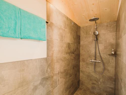 a bathroom with a shower with a blue towel at Alpin - Studios & Suites in Warth am Arlberg