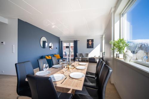 a dining room with a long wooden table and black chairs at Arctic Homes - Premium Tromsø Residence in Tromsø