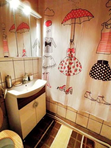 un bagno con lavandino e ombrelli appesi al muro di Happy place :) a Hunedoara