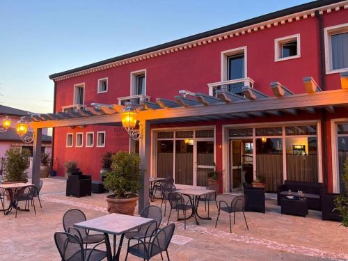 a patio with tables and chairs in front of a building at Hotel Fuori Città in Stanghella