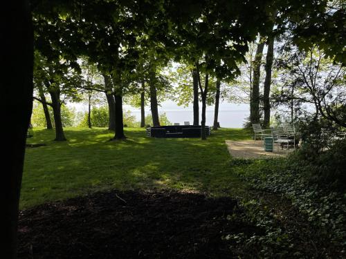 a park with trees and a picnic table in the grass at All the Waters Retro Home on Lake Michigan- Your Own PRIVATE BEACH in Benton Harbor