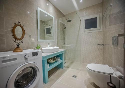 bagno con lavatrice e lavandino di Augoustinos Luxury Villa a Sarakinádhon