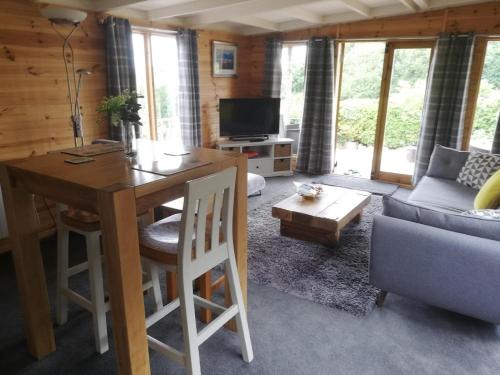 sala de estar con mesa y sofá en Peaceful Cabin Retreat in Skegby, en Sutton-in-Ashfield