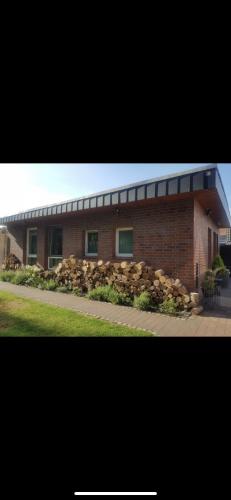 a brick building with a stone wall in front of it at Mini-Bungalow in Delmenhorst