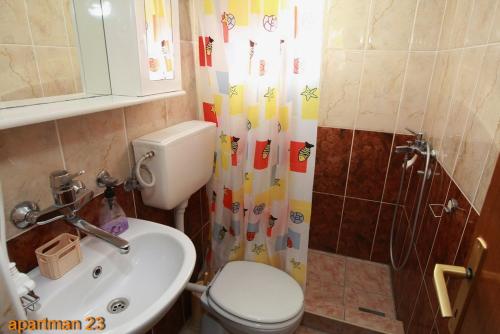 e bagno con servizi igienici, lavandino e doccia. di Apartmani Dubravka a Rafailovici