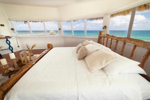 a bedroom with a bed with a view of the ocean at Quinta del Mar Crystal Beach in Tintipan Island