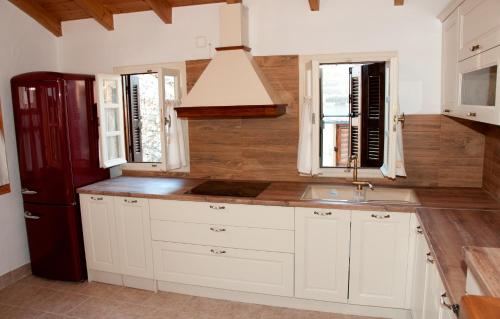 a kitchen with white cabinets and a sink at Pyrgos Fassea Kardamyli in Kardamyli