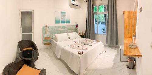 un soggiorno con divano bianco e letto di Fins Dive and Leisure Hotel a Rasdhoo