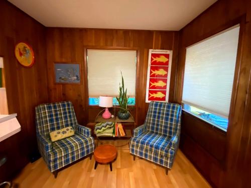 a living room with two chairs and a table at All the Waters Retro Home on Lake Michigan- Your Own PRIVATE BEACH in Benton Harbor