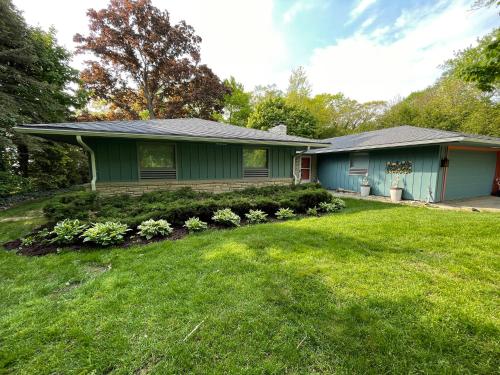 a home with a green house with a yard at All the Waters Retro Home on Lake Michigan- Your Own PRIVATE BEACH in Benton Harbor