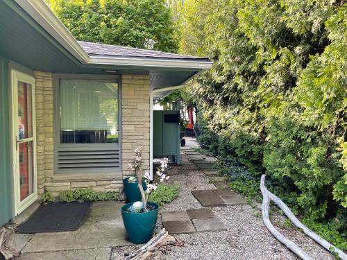 a house with two large plants in front of it at All the Waters Retro Home on Lake Michigan- Your Own PRIVATE BEACH in Benton Harbor