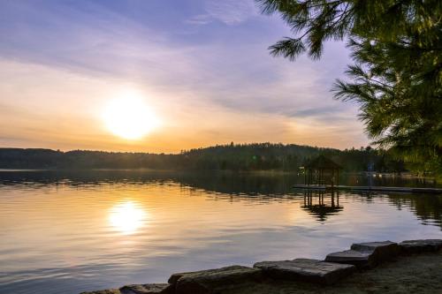 a sunset over a lake with a gazebo at Muskoka Waterfront Retreat in Dwight