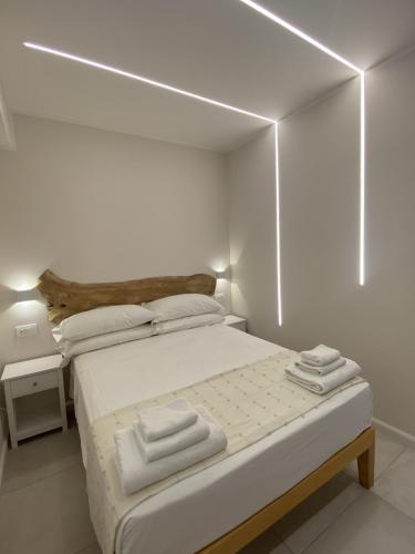 a white bedroom with a bed with towels on it at Koralline accommodation in Tropea