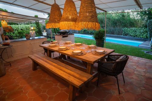- une table et des chaises en bois dans une cuisine avec une table dans l'établissement Villa Les Muscadines Saint Tropez, Plage de Tahiti Pampelonne, à Saint-Tropez