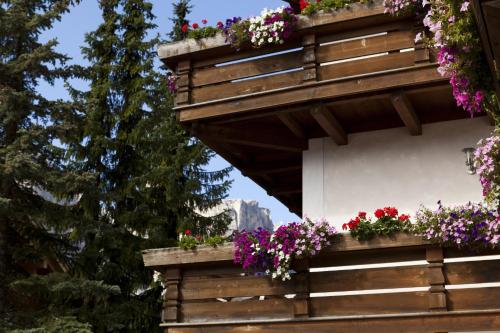 a balcony with flowers on the side of a building at Pensione Haus Erica in Colfosco