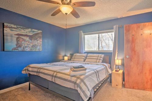 1 dormitorio azul con 1 cama y ventilador de techo en Lovely Colorado Springs Home Mtn Views and Hot Tub!, en Colorado Springs