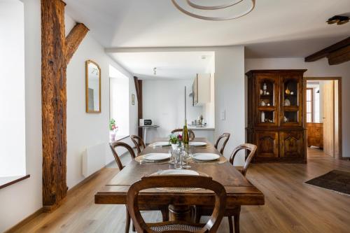 ein Esszimmer mit einem Holztisch und Stühlen in der Unterkunft LE RHENANUS Martin Bucer - grand appartement au calme - centre ville - parking gratuit in Sélestat