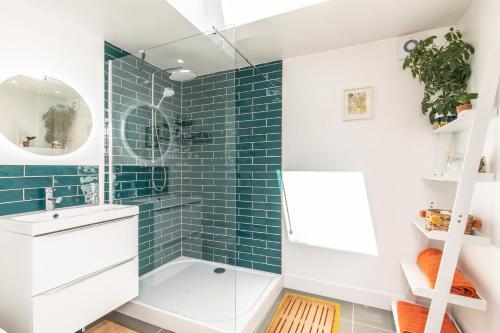 a bathroom with blue subway tile and a sink at Beach, hills, food, scenic walks-The Kelp house. in Peacehaven