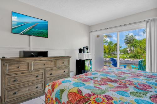 Coconut Cay Resort في ماراثون: غرفة نوم بسرير وتلفزيون بشاشة مسطحة