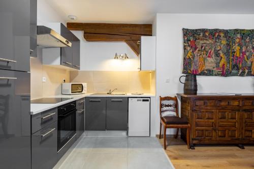 une cuisine équipée d'appareils en acier inoxydable et d'une peinture murale. dans l'établissement LE RHENANUS Ludwig Dringenberg - appartement au calme - centre ville - parking gratuit, à Sélestat