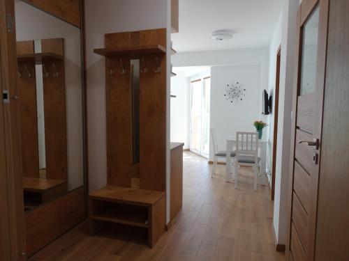 um corredor com armários de madeira e uma sala de jantar em ApartamentPromenadaEłk em Ełk
