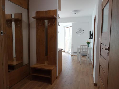 a hallway with wooden cabinets and a dining room at ApartamentPromenadaEłk in Ełk