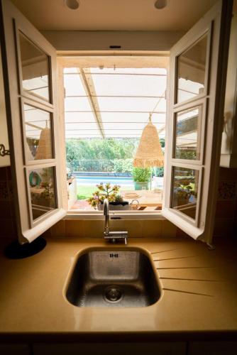d'un évier de cuisine avec une fenêtre et une vue sur la cour. dans l'établissement Villa Les Muscadines Saint Tropez, Plage de Tahiti Pampelonne, à Saint-Tropez