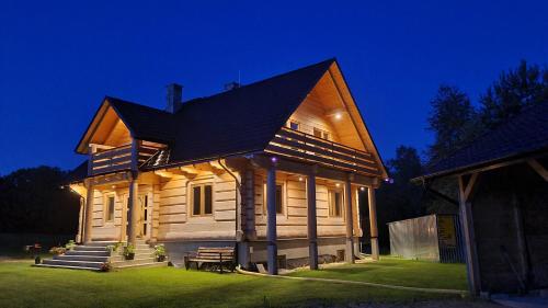 a large wooden house with a gambrel roof at Drewniana chata in Cisówek