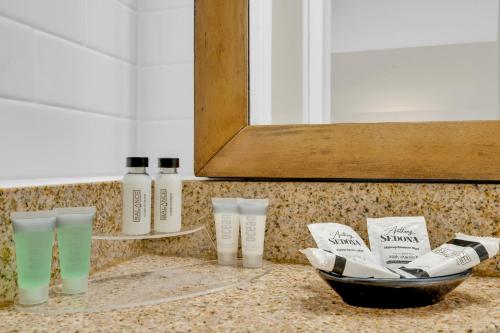 a bathroom counter with bottles of shampoo and a bowl at Coconut Cay Resort in Marathon