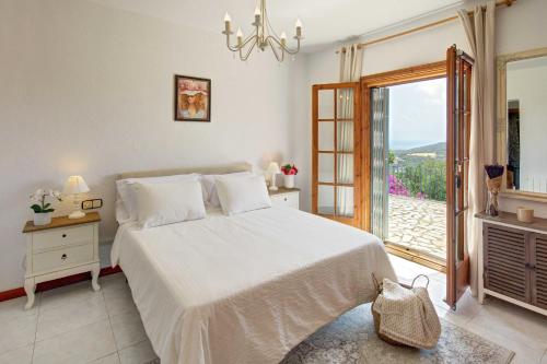 biała sypialnia z łóżkiem i oknem w obiekcie VILLA MARIA with swimming pool & sea view w mieście Calonge